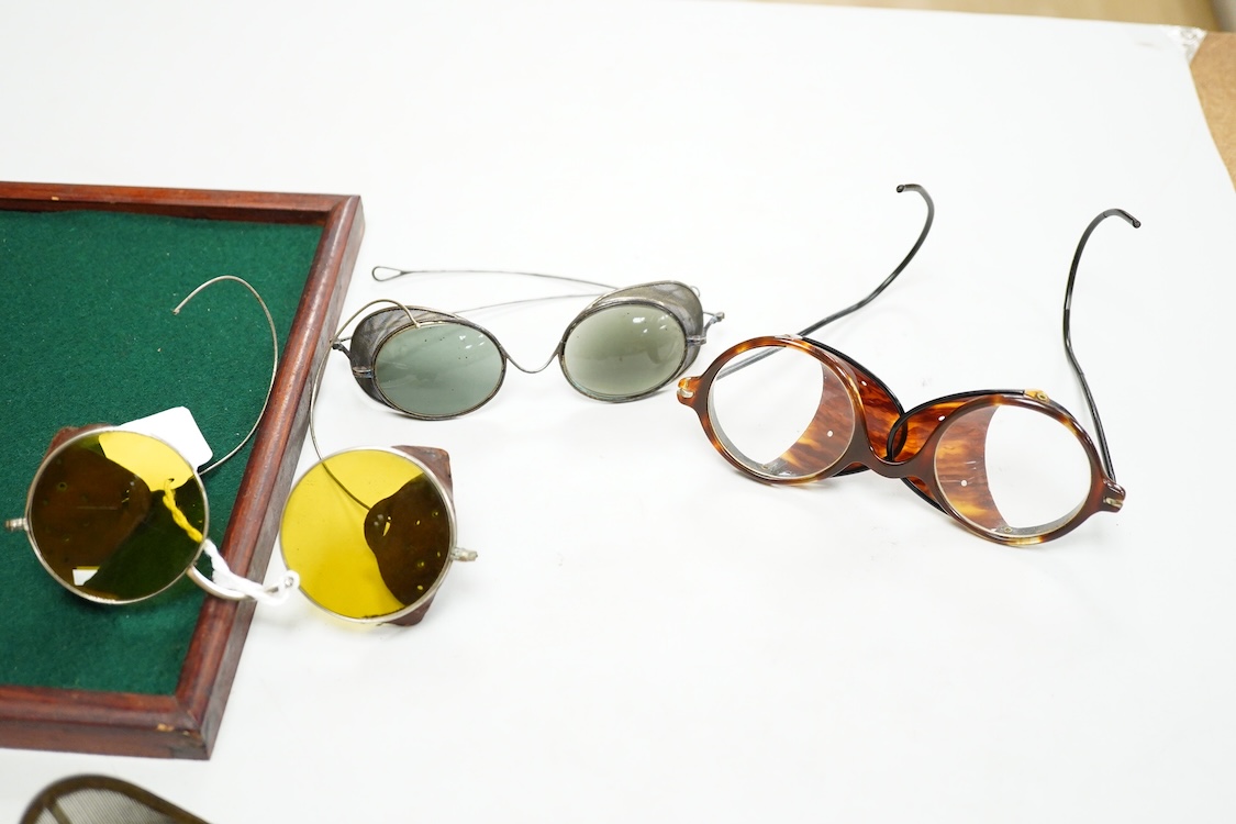 A pair of early 20th century Theodore Hamblin safety goggles with mesh wire sides, with original case, a pair of prescription mesh sided safety glasses, a pair of faux tortoiseshell safety glasses and a pair of Willson,